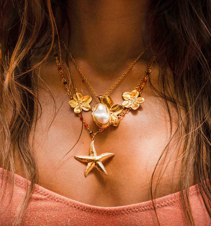 Woman wearing layered necklaces.